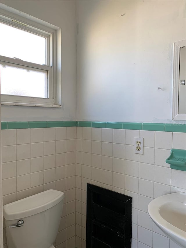 bathroom with tile walls and toilet