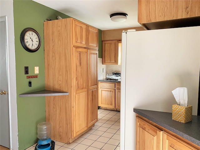 kitchen with white fridge and light tile patterned flooring