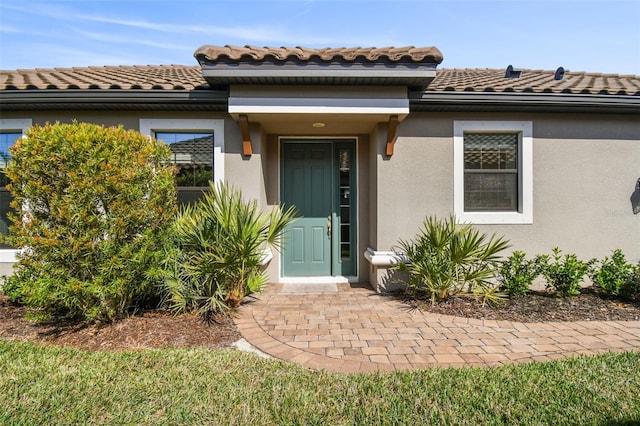 property entrance featuring stucco siding and a tiled roof