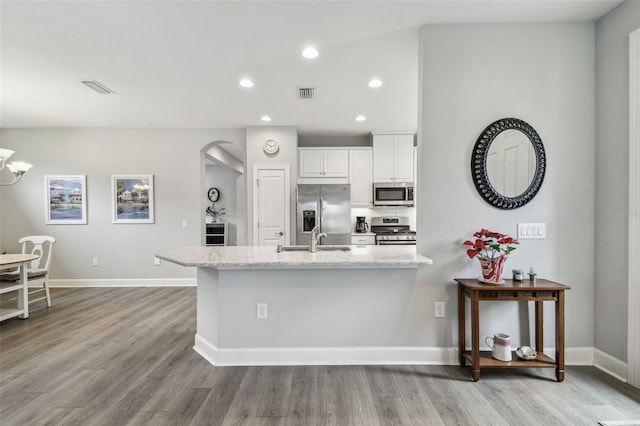 kitchen with light stone counters, visible vents, appliances with stainless steel finishes, and a sink