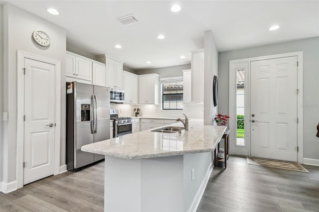 kitchen featuring appliances with stainless steel finishes, sink, white cabinets, and plenty of natural light