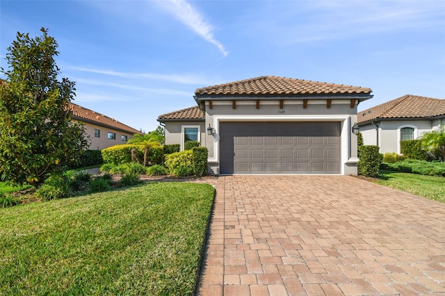 mediterranean / spanish-style house with a tile roof, a front yard, stucco siding, decorative driveway, and an attached garage