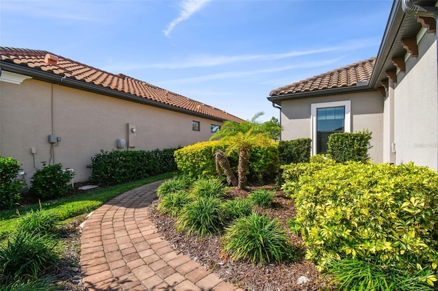 view of property exterior featuring a tile roof and stucco siding