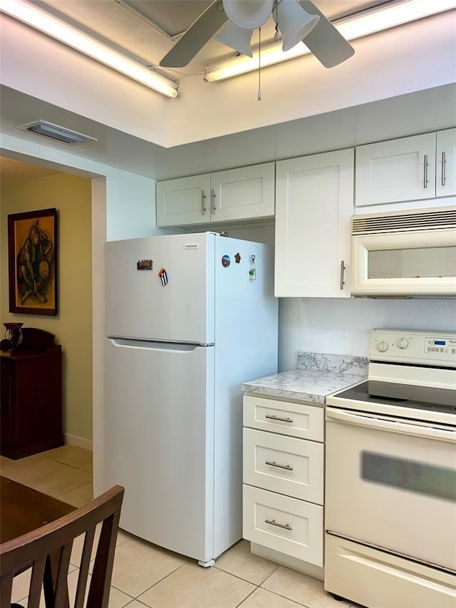 kitchen with white cabinetry, light tile patterned floors, white appliances, and ceiling fan