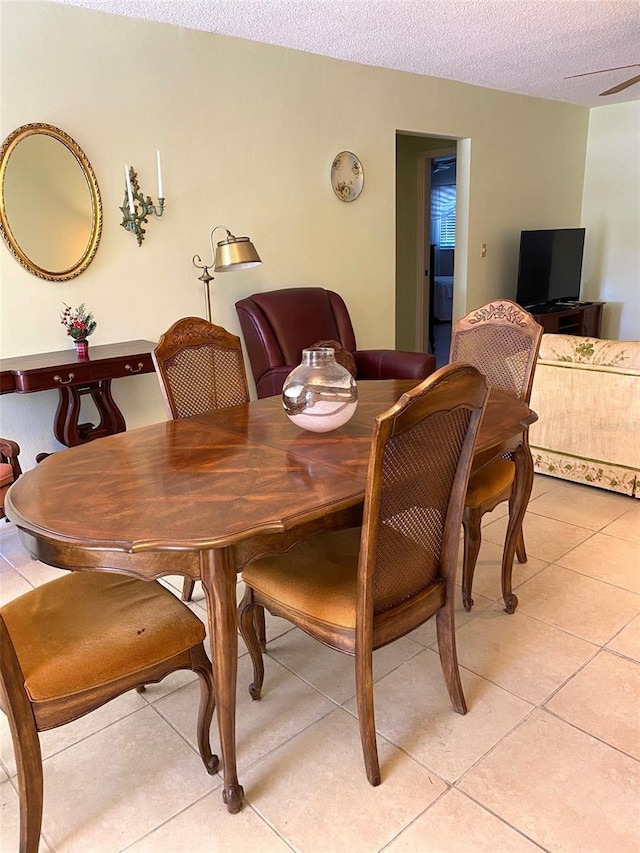 dining area featuring a textured ceiling and light tile patterned flooring