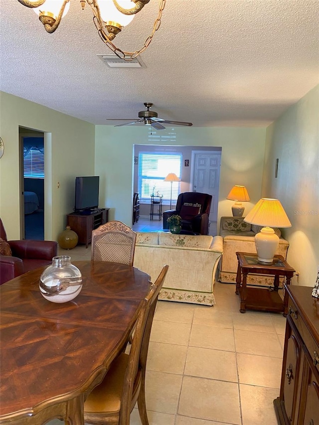 tiled dining area featuring ceiling fan and a textured ceiling