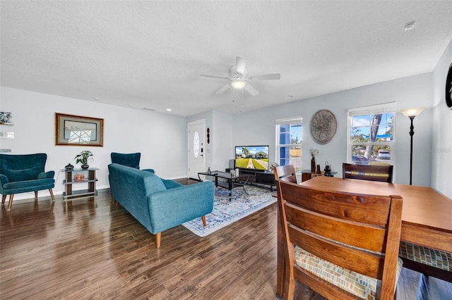 living room featuring ceiling fan, dark hardwood / wood-style floors, and a textured ceiling