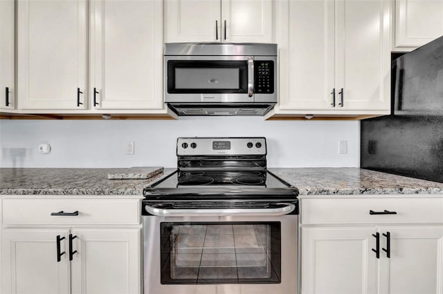 kitchen with appliances with stainless steel finishes, white cabinets, and light stone counters