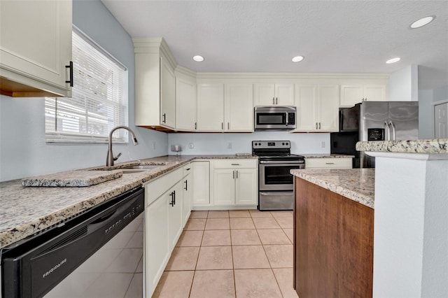 kitchen with white cabinetry, sink, light tile patterned floors, and appliances with stainless steel finishes