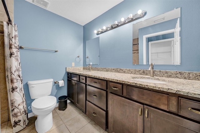 bathroom with vanity, curtained shower, tile patterned floors, and toilet