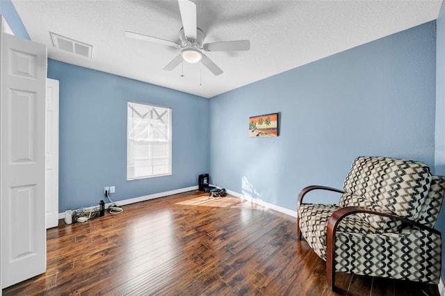 sitting room featuring dark hardwood / wood-style floors, a textured ceiling, and ceiling fan