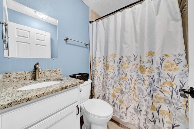 bathroom featuring vanity, toilet, and a textured ceiling