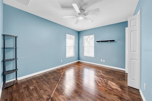 empty room featuring dark hardwood / wood-style floors, a textured ceiling, and ceiling fan