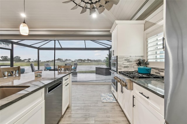 kitchen featuring hanging light fixtures, stainless steel appliances, and white cabinets