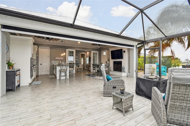 view of patio / terrace with an outdoor living space with a fireplace and glass enclosure