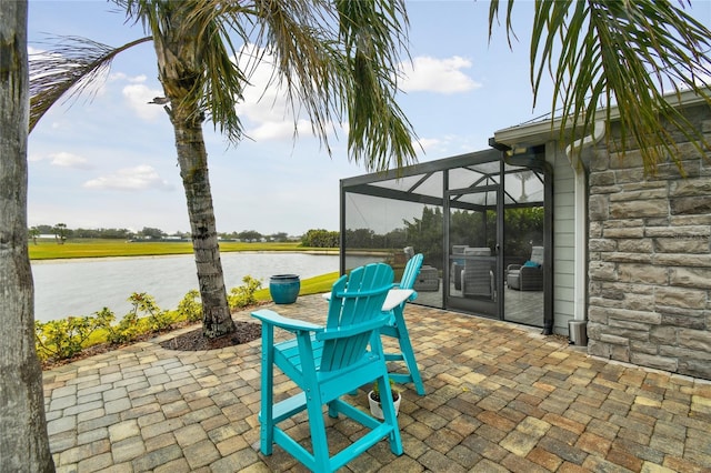 view of patio featuring a water view and glass enclosure