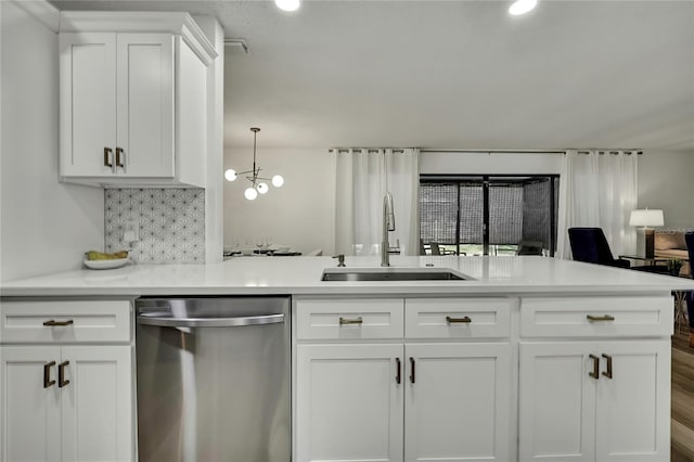 kitchen featuring sink, backsplash, white cabinets, decorative light fixtures, and stainless steel dishwasher