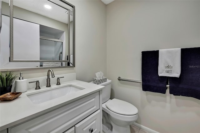 bathroom with vanity, toilet, and a shower with shower door