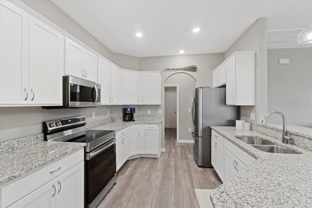 kitchen with white cabinetry, appliances with stainless steel finishes, light hardwood / wood-style floors, and sink