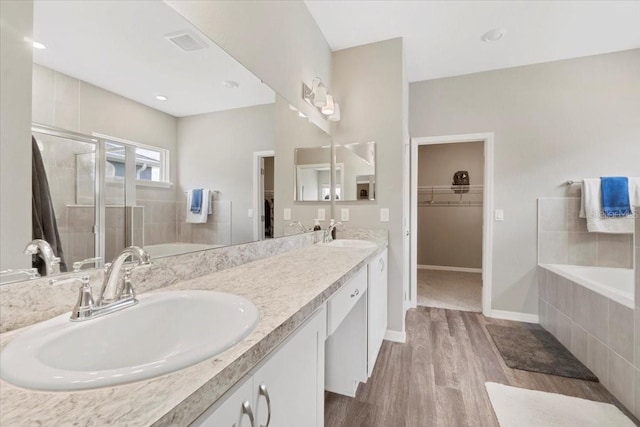 bathroom featuring vanity, hardwood / wood-style floors, and shower with separate bathtub