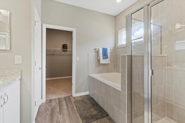 bathroom featuring wood-type flooring, independent shower and bath, and vanity