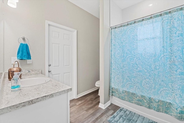 full bathroom with hardwood / wood-style flooring, vanity, toilet, and shower / bath combo with shower curtain