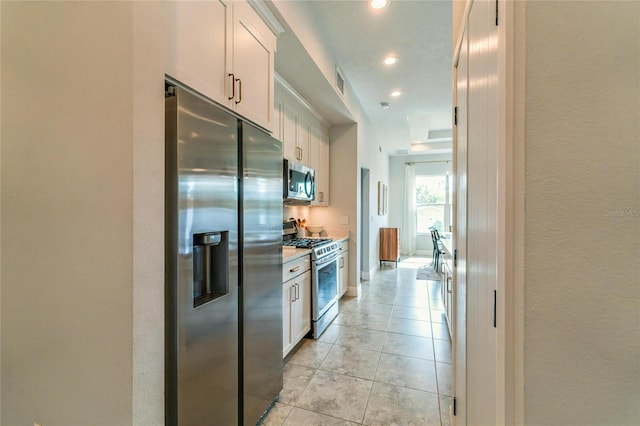 kitchen featuring white cabinetry, appliances with stainless steel finishes, and light tile patterned flooring