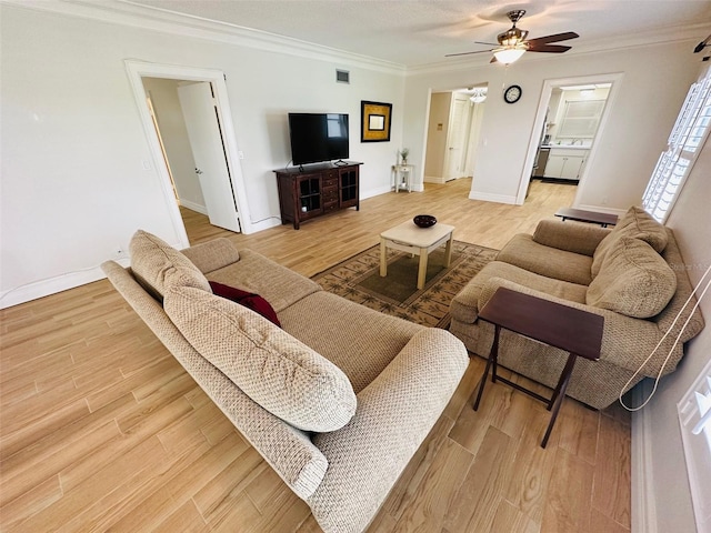 living room with wood-type flooring, ceiling fan, and crown molding