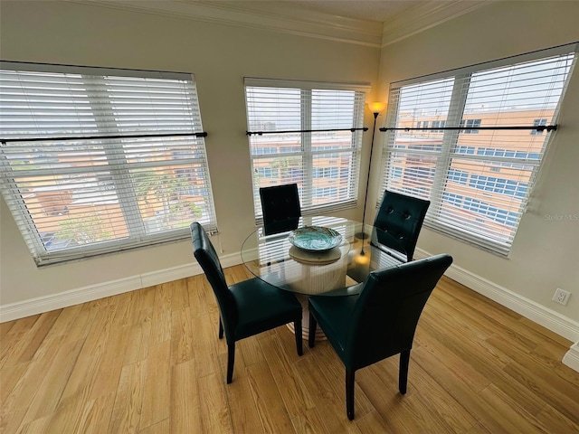 dining room with crown molding, plenty of natural light, and light hardwood / wood-style flooring