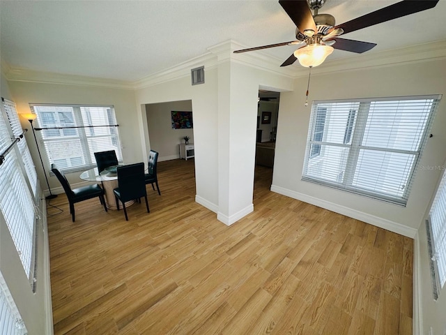 unfurnished dining area with crown molding, plenty of natural light, and light wood-type flooring