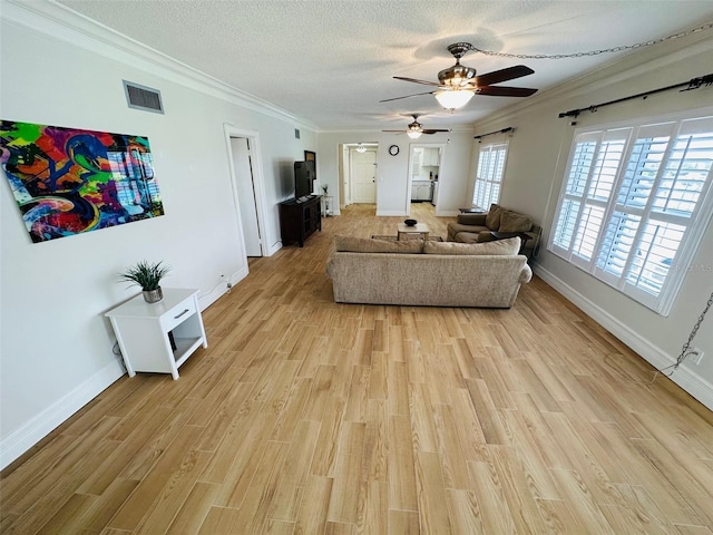 living room with ceiling fan, light hardwood / wood-style flooring, ornamental molding, and a textured ceiling