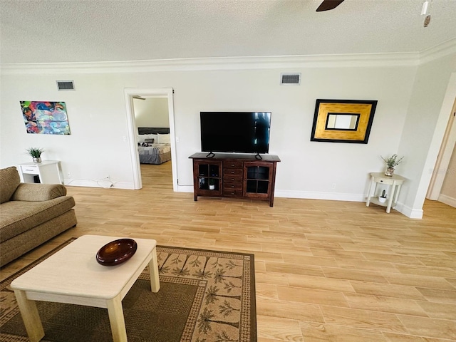 living room featuring ornamental molding, a textured ceiling, and light hardwood / wood-style flooring