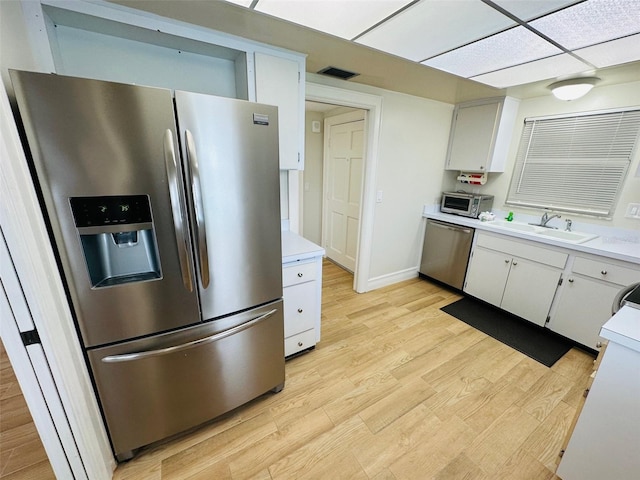 kitchen featuring white cabinetry, appliances with stainless steel finishes, sink, and light hardwood / wood-style floors