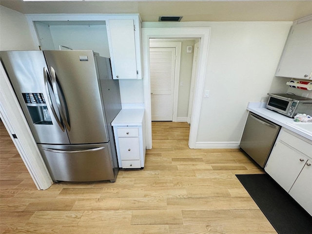 kitchen featuring appliances with stainless steel finishes, sink, white cabinets, and light hardwood / wood-style floors