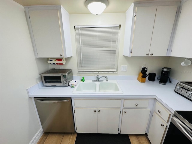 kitchen with stainless steel dishwasher, sink, light hardwood / wood-style flooring, and white cabinets