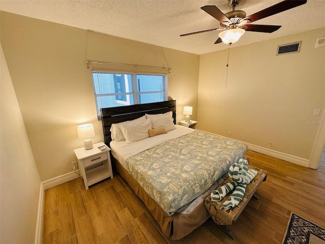 bedroom featuring a textured ceiling, ceiling fan, and light hardwood / wood-style floors