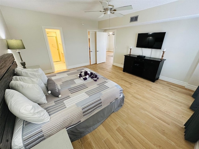 bedroom with ensuite bath, ceiling fan, and light hardwood / wood-style flooring