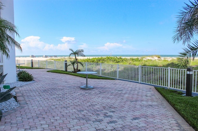 view of patio featuring a water view and a view of the beach