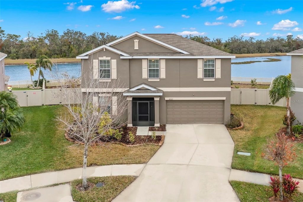 view of property with a water view, a garage, and a front lawn