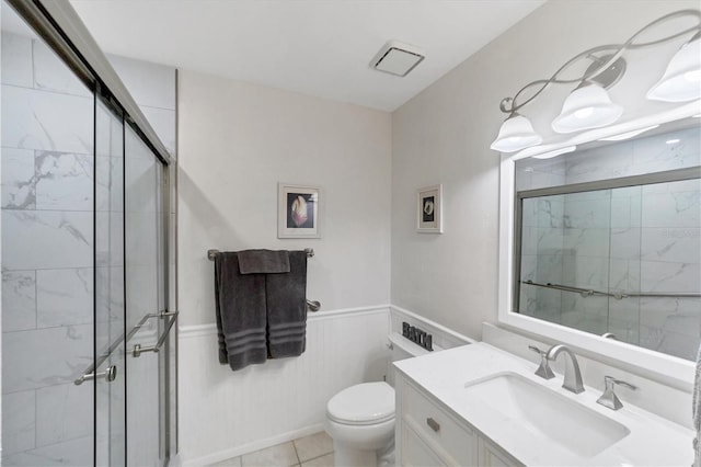 bathroom with a shower with door, vanity, and toilet