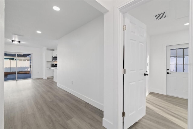 hallway with light hardwood / wood-style floors