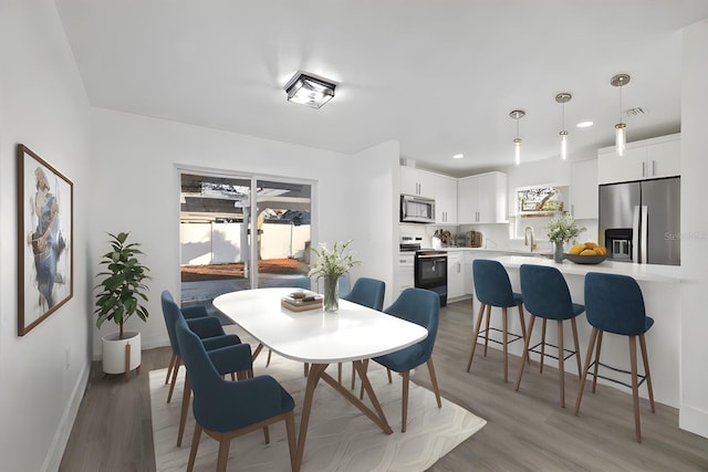 dining space featuring sink and hardwood / wood-style flooring