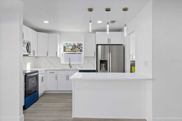 kitchen with sink, appliances with stainless steel finishes, pendant lighting, light stone countertops, and white cabinets