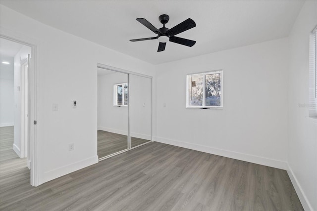 unfurnished bedroom with hardwood / wood-style flooring, a closet, and ceiling fan