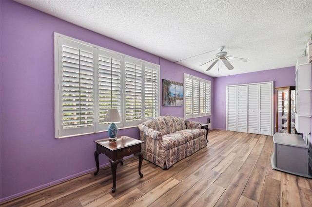 sitting room featuring ceiling fan, a textured ceiling, and light hardwood / wood-style floors