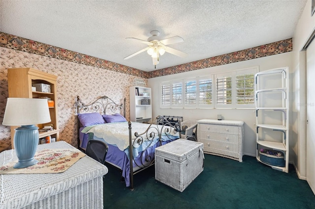 carpeted bedroom featuring ceiling fan and a textured ceiling