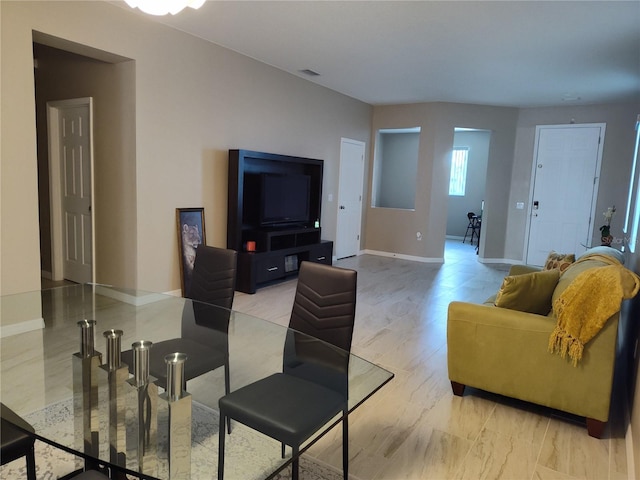 living area with baseboards and visible vents