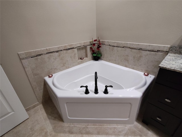 full bathroom featuring tile patterned floors, a bath, and vanity