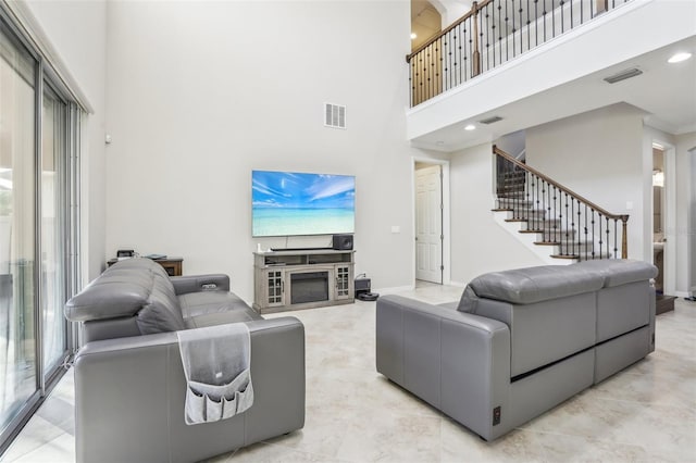 living room featuring a towering ceiling and ornamental molding