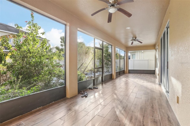 unfurnished sunroom featuring ceiling fan